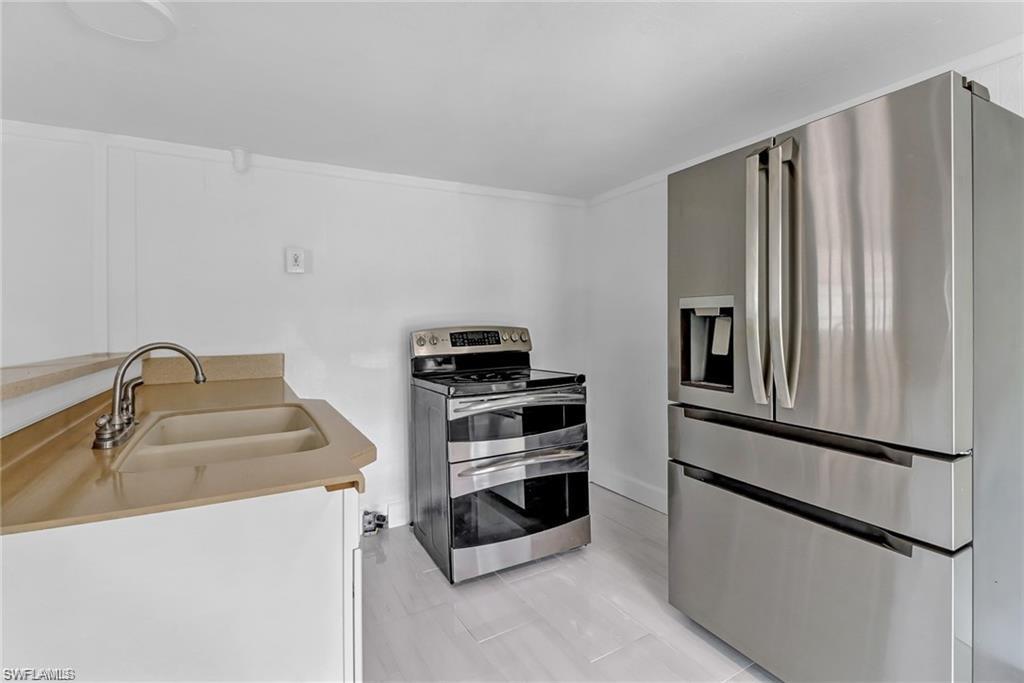 120 Grassy Key Lane, Unit 38 Naples, FL 34114 - Photo 10 of 28 a kitchen with stainless steel appliances a refrigerator sink and microwave