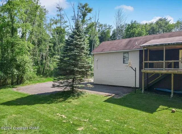 an aerial view of a house with a yard fountain and large tree