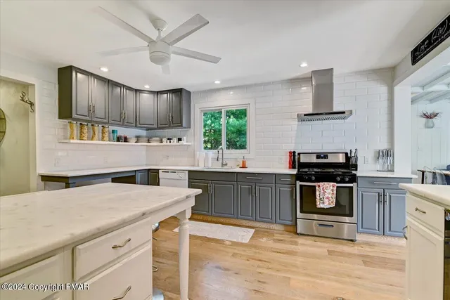 a kitchen with stainless steel appliances a table and chairs in it
