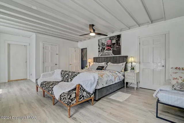 a bedroom with bed and wooden floor