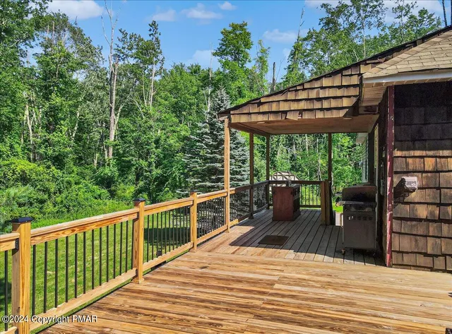 a view of a patio with couches chairs and wooden floor