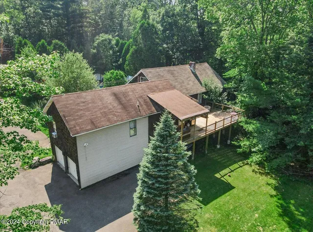 an aerial view of a house with a yard basket ball court and outdoor seating
