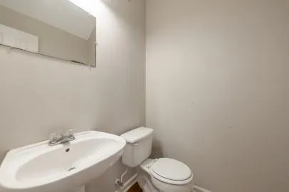 a white toilet sitting next to a white sink