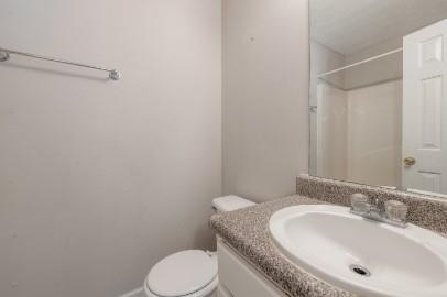5450 Hampton Court Atlanta, GA 30349 - Photo 14 of 15 a bathroom with a granite countertop toilet sink and mirror
