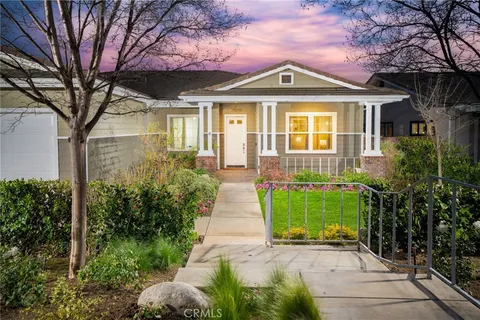 a front view of a house with a yard and potted plants