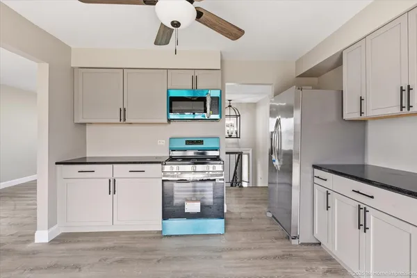 a kitchen with kitchen island white cabinets and stainless steel appliances