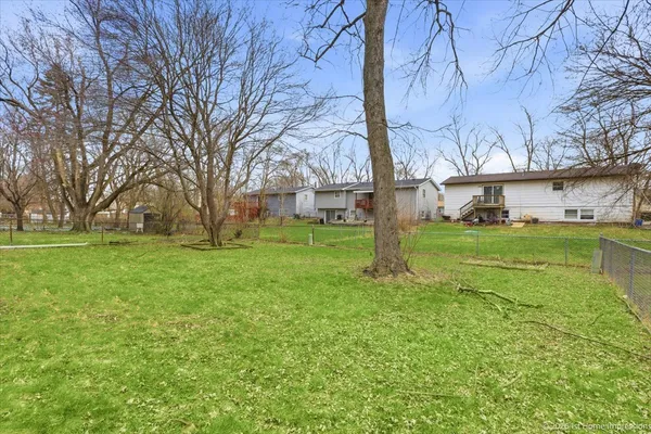 a view of a house with backyard and a tree