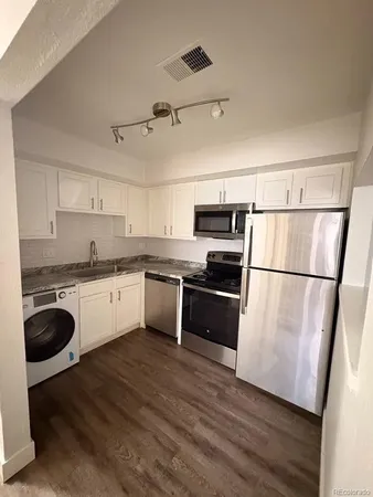 a kitchen with granite countertop a refrigerator oven a sink and dishwasher