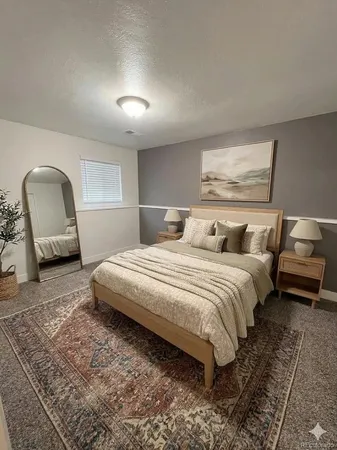 a bedroom with a bed a mirror and desk