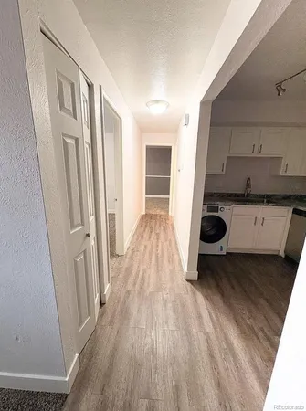 a kitchen with a wooden floor and cabinets