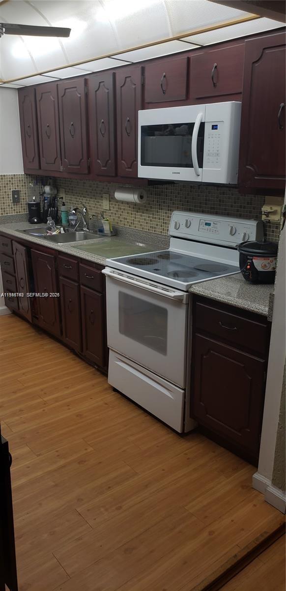 3426 Spring Bluff Place, Unit 36 Lauderhill, FL 33319 - Photo 11 of 14 a kitchen with stainless steel appliances granite countertop a stove a sink and a microwave