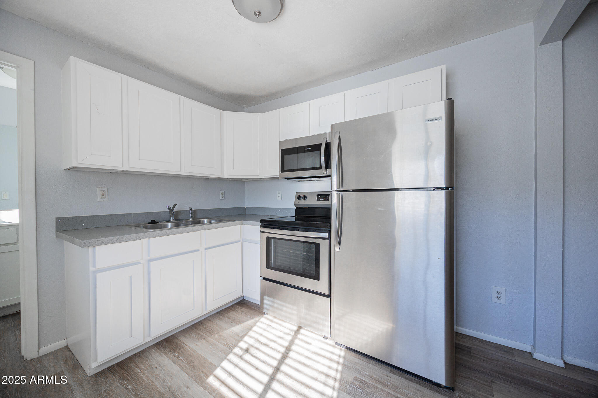 1026 East Pierce Street, Unit B Phoenix, AZ 85006 - Photo 11 of 14 a kitchen with a refrigerator stove and white cabinets