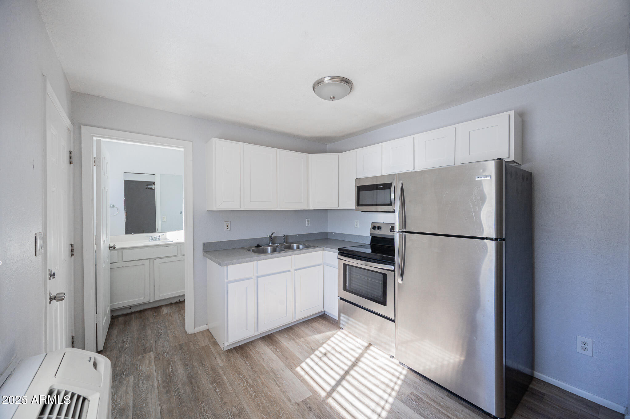 1026 East Pierce Street, Unit B Phoenix, AZ 85006 - Photo 10 of 14 a kitchen with a refrigerator a stove top oven and cabinets