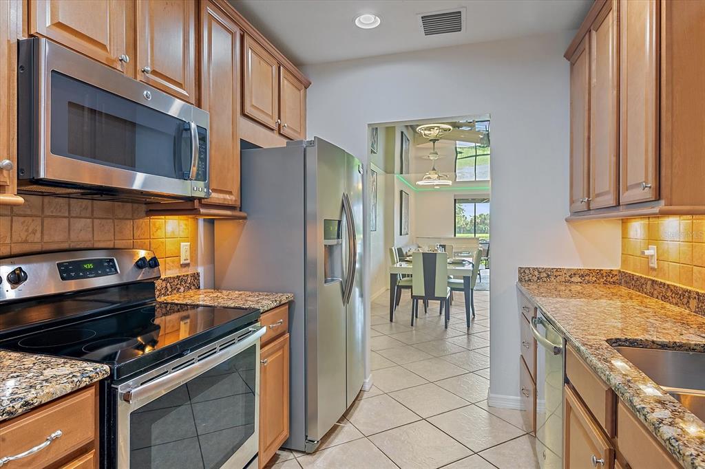 7325 Skybird Road, Unit 399 Bradenton, FL 34209 - Photo 14 of 49 a kitchen with stainless steel appliances granite countertop a stove microwave and refrigerator