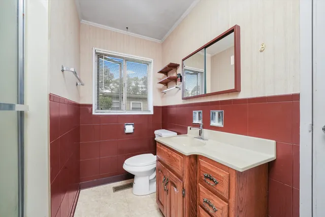 a bathroom with a sink a toilet and mirror