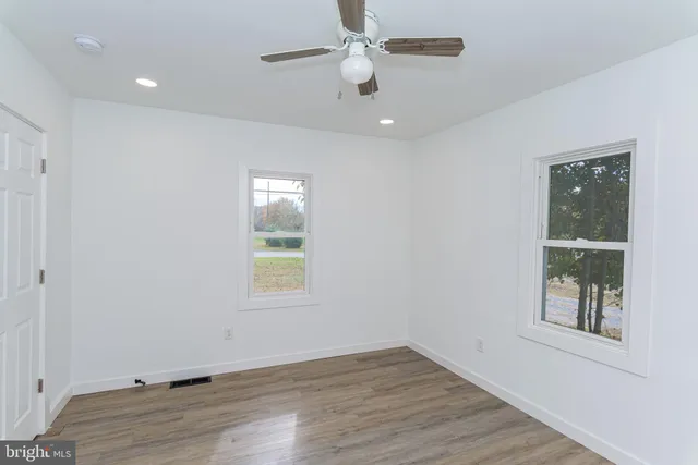a view of an empty room with wooden floor