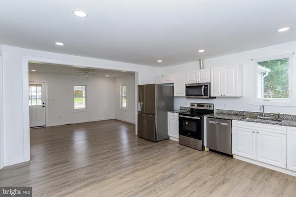 a view of a kitchen with wooden floor and a refrigerator