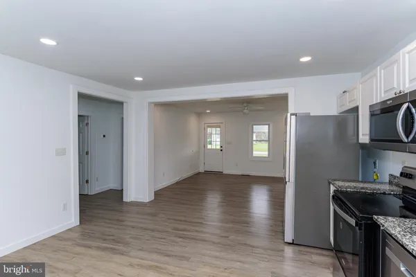 an empty room with wooden floor and a ceiling fan