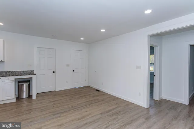 an empty room with wooden floor window and closet