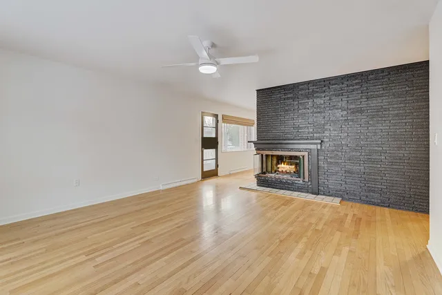 a view of empty room with wooden floor and fireplace