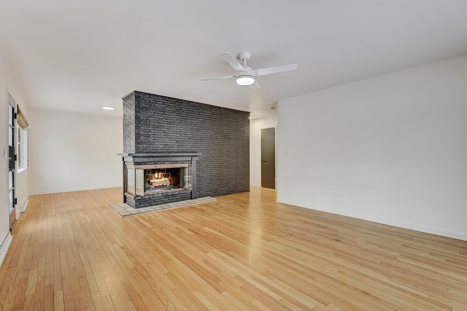 1343 Oxford Road Deerfield, IL 60015 - Photo 2 of 28 a view of an empty room with wooden floor fireplace and a window