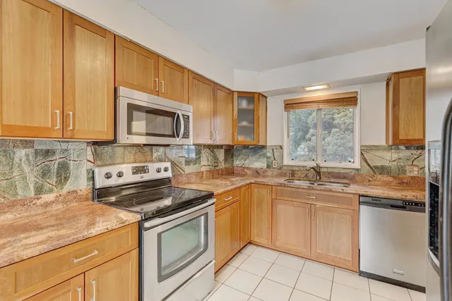 a kitchen with stainless steel appliances granite countertop a sink stove and microwave