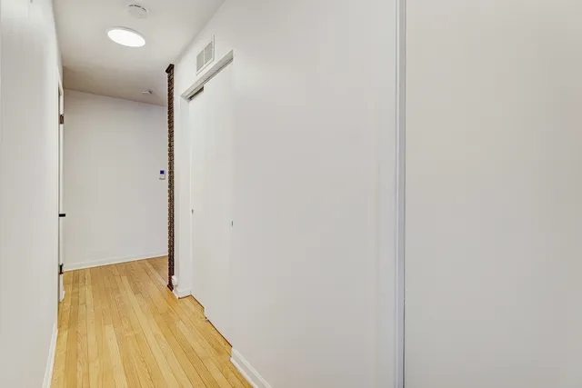 a view of a room with wooden floor and a bathroom