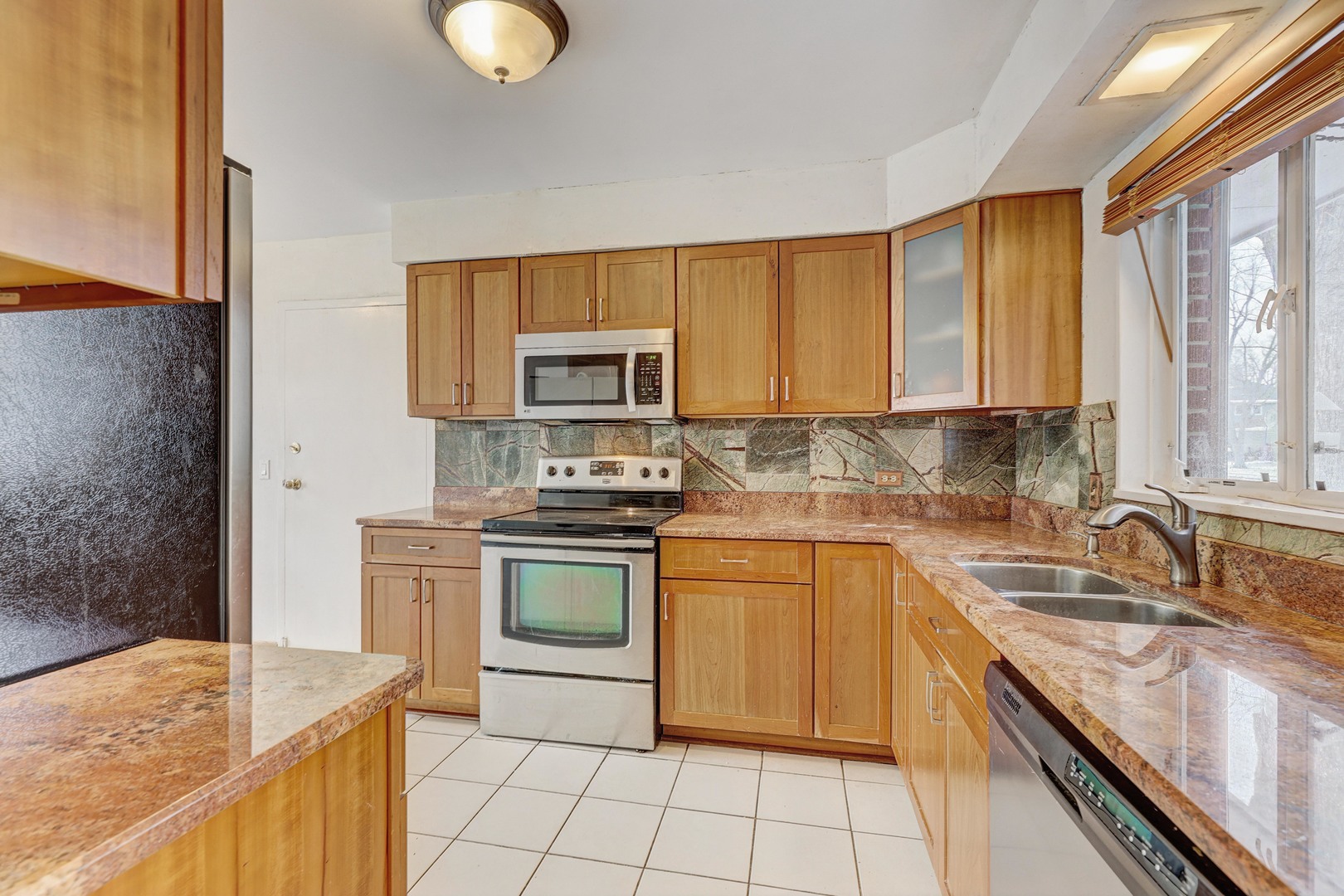 1343 Oxford Road Deerfield, IL 60015 - Photo 8 of 28 a kitchen with stainless steel appliances granite countertop a sink stove and microwave