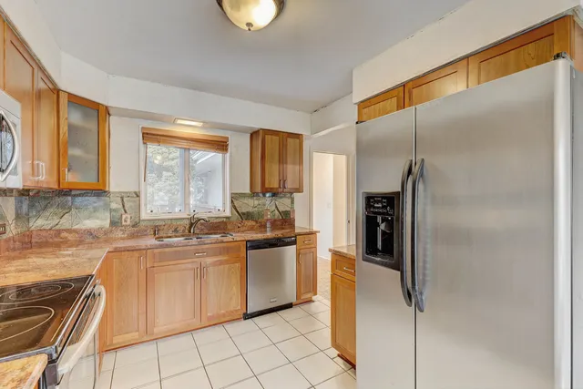 a kitchen with stainless steel appliances granite countertop a refrigerator and a sink