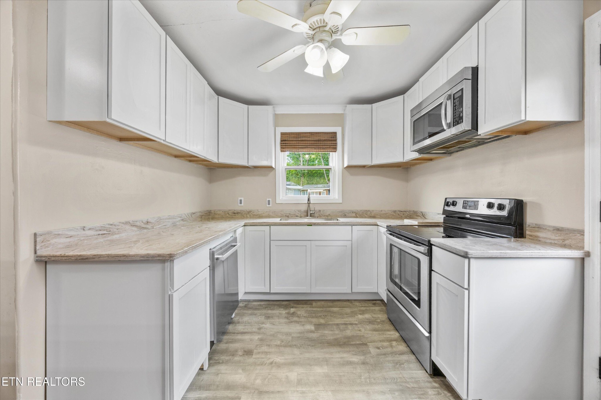 135 West Arrowwood Road Oak Ridge, TN 37830 - Photo 10 of 29 a kitchen with stainless steel appliances granite countertop a sink and dishwasher a stove top oven with white cabinets