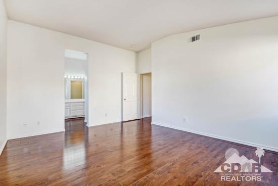 841 Homestead Road Corona, CA 92878 - Photo 15 of 21 an empty room with wooden floor and bathroom view