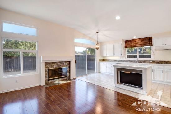 841 Homestead Road Corona, CA 92878 - Photo 4 of 21 an empty room with wooden floor a fireplace and a window