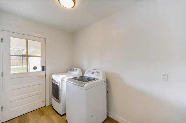 an empty room with wooden floor ceiling fan and windows