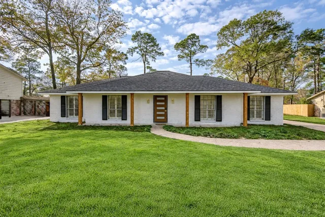 a white house that has a tree in front of it