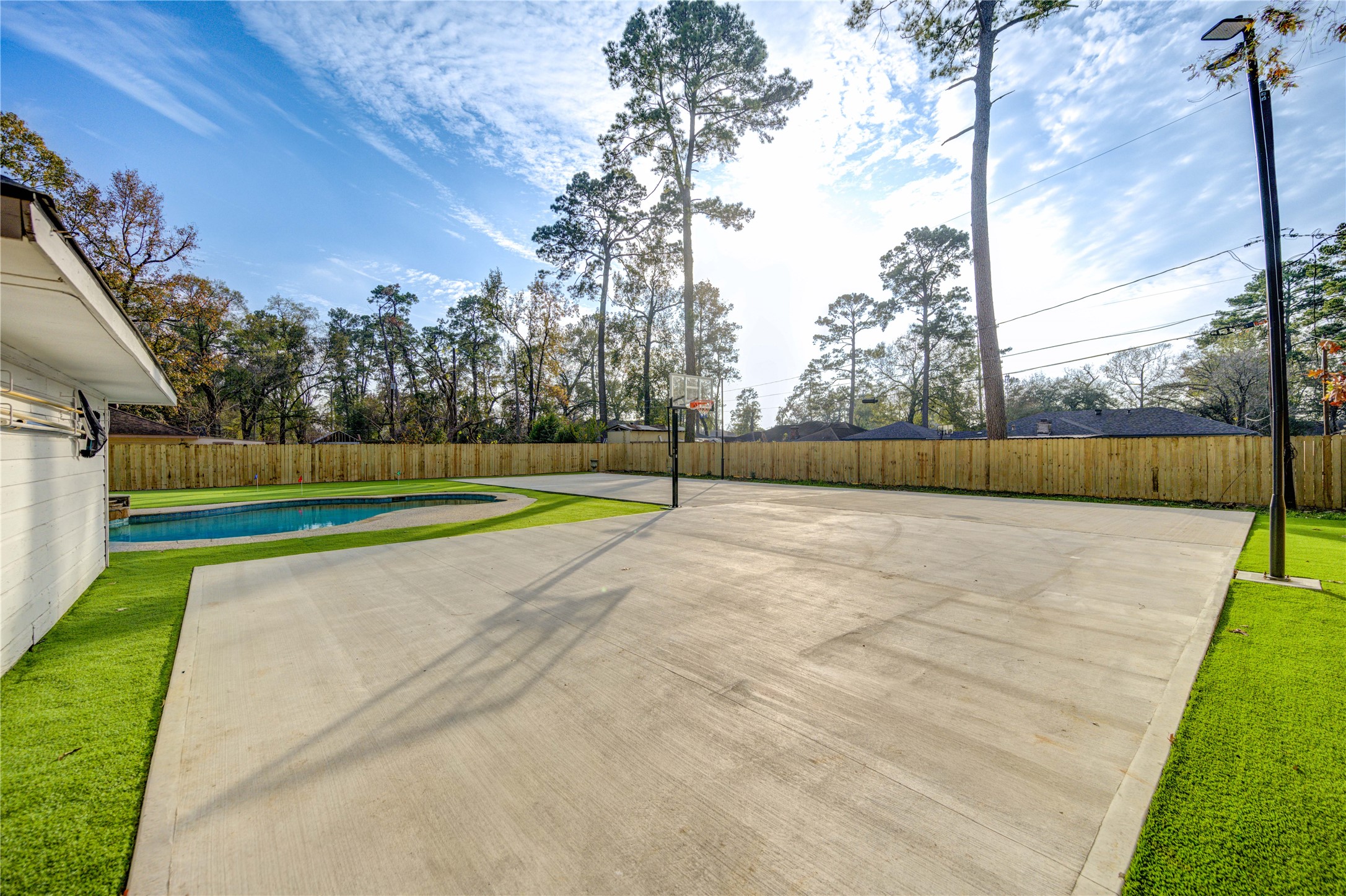 25607 Spring Ridge Drive Spring, TX 77386 - Photo 43 of 50 Expansive 3600 sf concrete ready for private sport courts with basketball hoop and two 16ft light poles, fully surrounded by artificial turf. Low maintenance and No space is wasted.