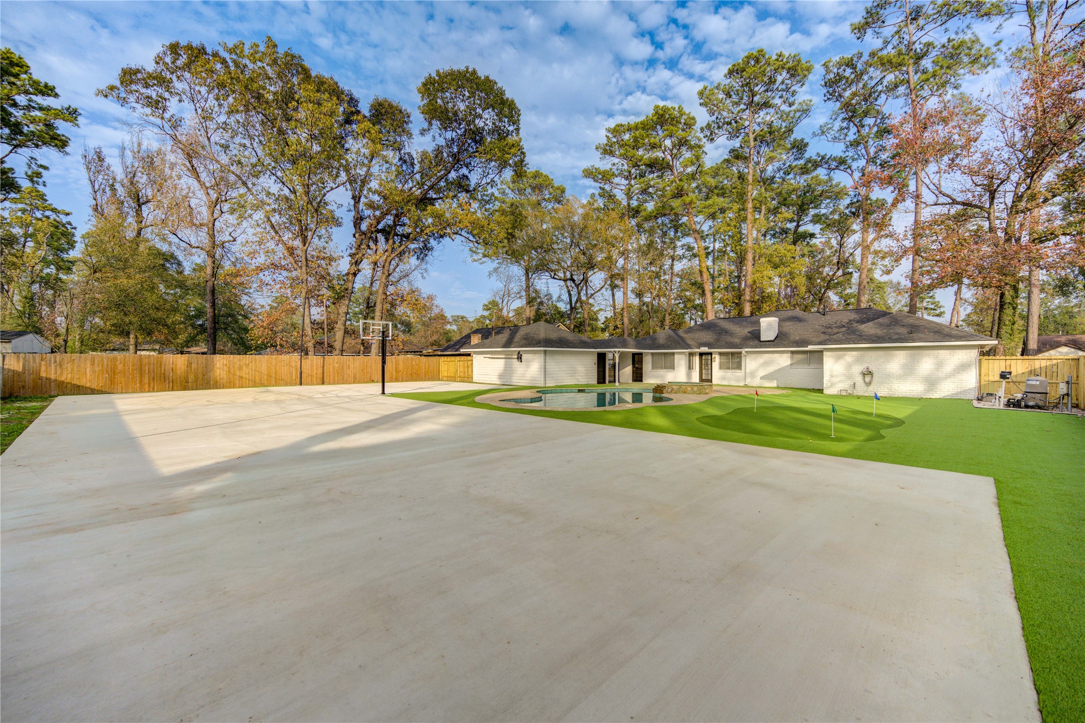 25607 Spring Ridge Drive Spring, TX 77386 - Photo 44 of 50 Expansive 3600 sf concrete ready for private sport courts with basketball hoop and two 16ft light poles, fully surrounded by artificial turf. Low maintenance and No space is wasted.