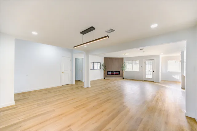 a view of kitchen with kitchen island a sink wooden floor and living room view