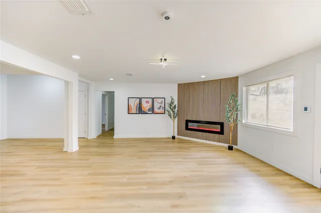 a kitchen with stainless steel appliances kitchen island granite countertop a sink a stove and a wooden floor