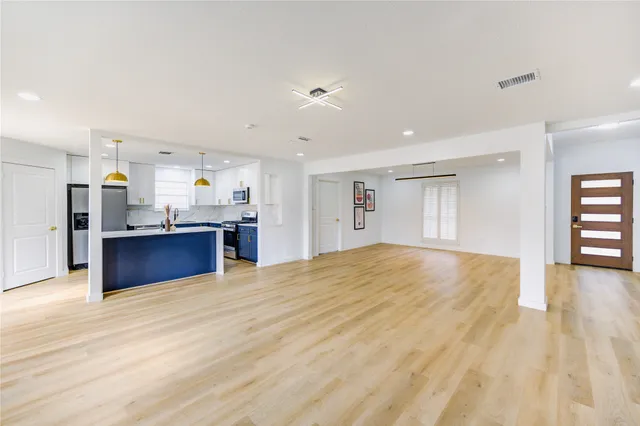 a view of a kitchen with kitchen island a counter top space cabinets stainless steel appliances and a window