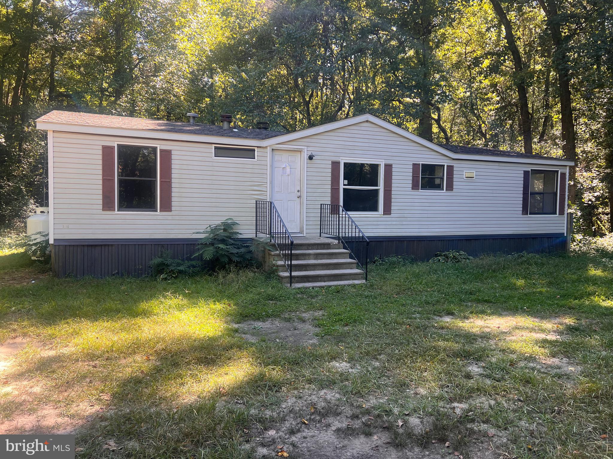 a view of a yard in front of a house with large trees