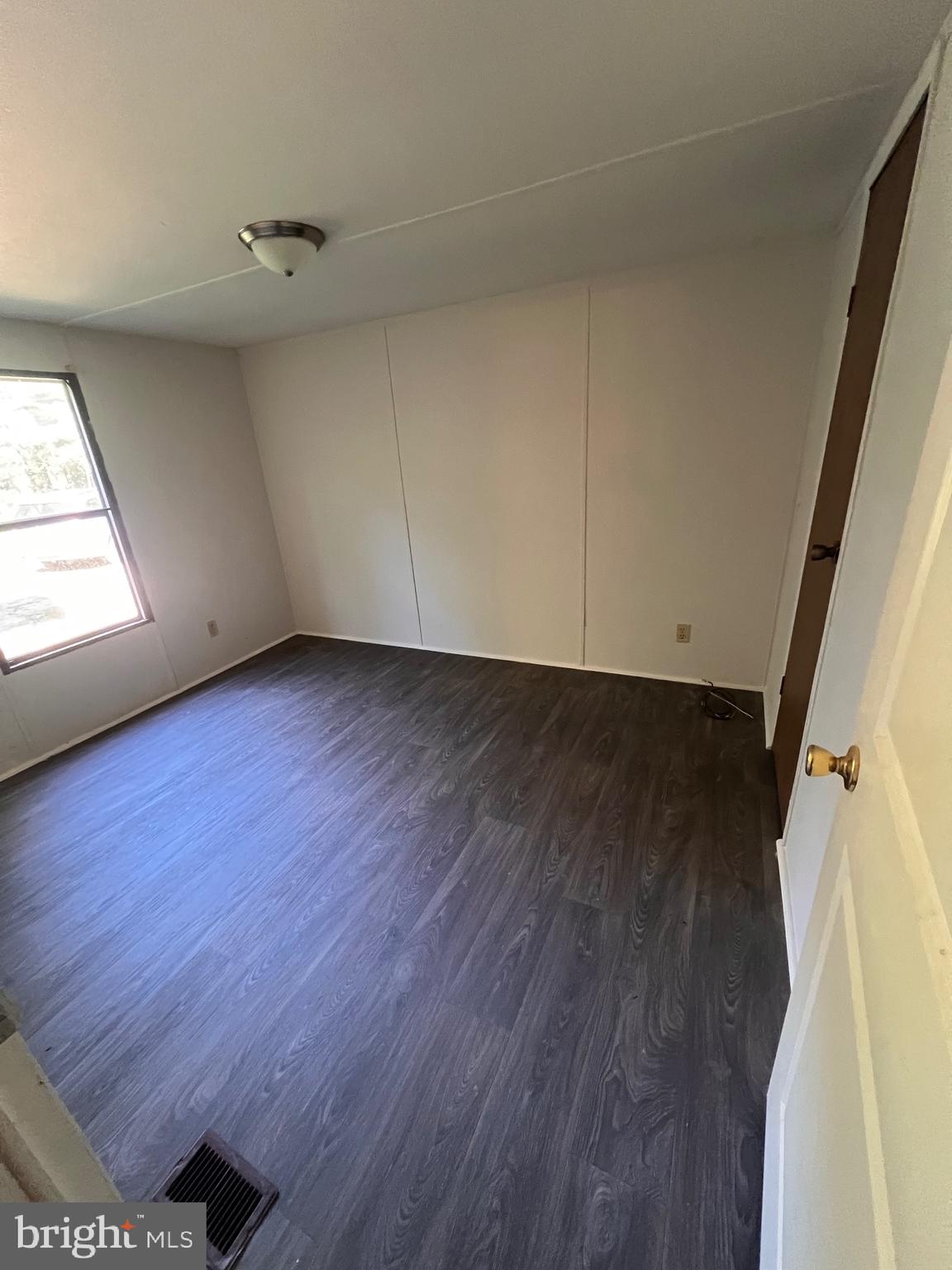 5215 Clark Canning House Road Hurlock, MD 21643 - Photo 7 of 10 an empty room with wooden floor and windows