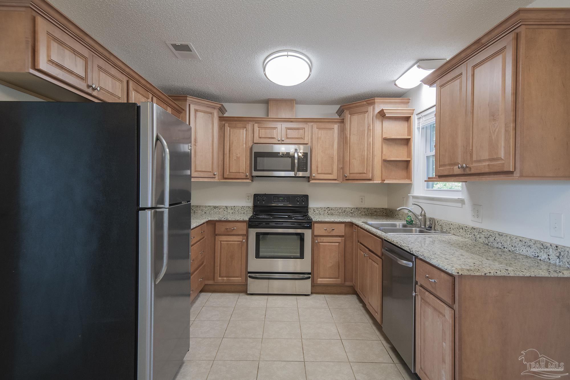 5578 Cyanamid Road Milton, FL 32583 - Photo 14 of 33 a kitchen with stainless steel appliances granite countertop a stove a sink and a refrigerator