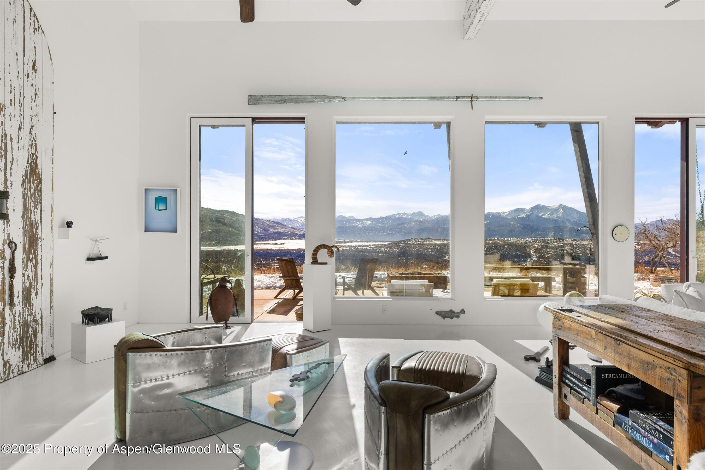 2103 Ten Peaks Mesa Road Carbondale, CO 81623 - Photo 12 of 52 a living room with furniture and a floor to ceiling window
