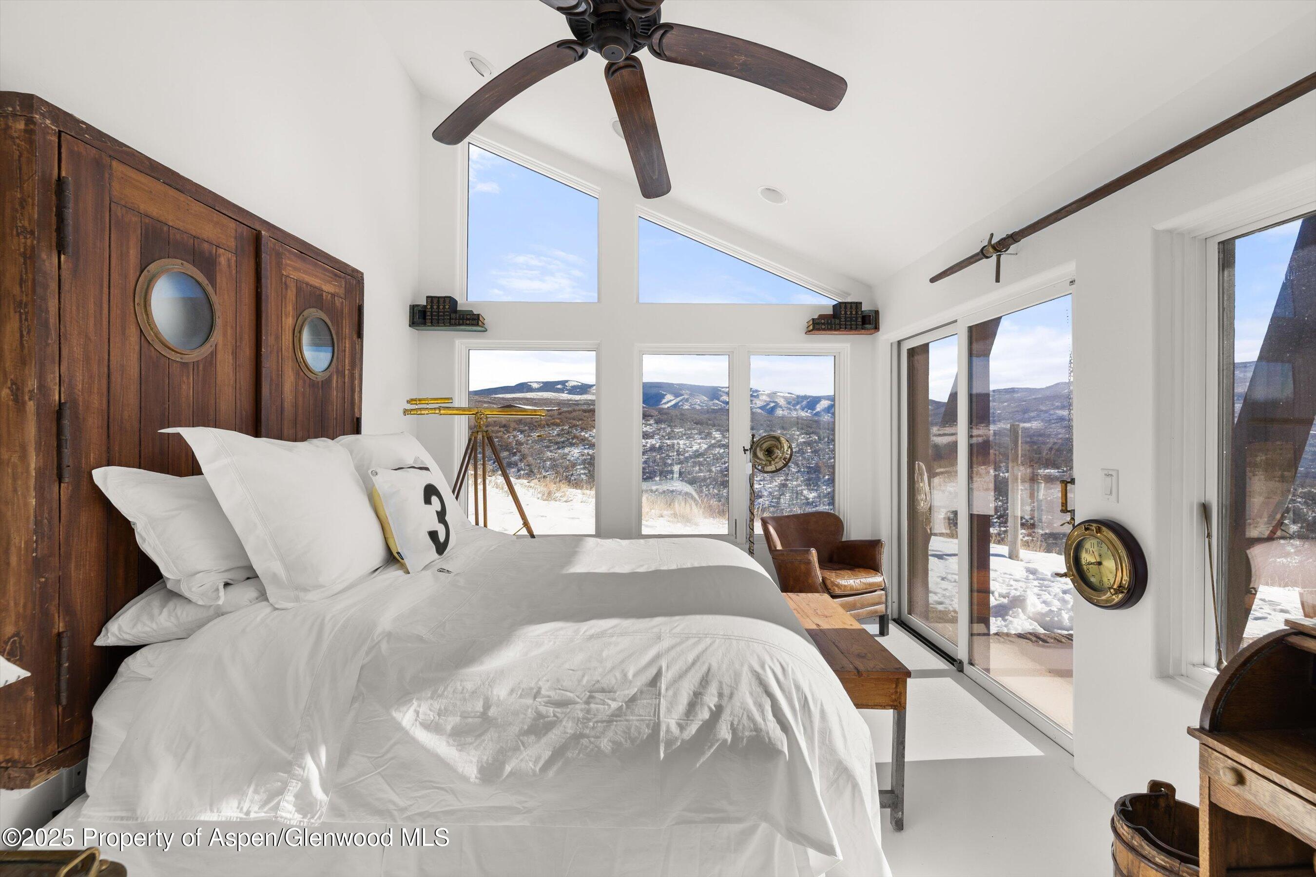 2103 Ten Peaks Mesa Road Carbondale, CO 81623 - Photo 33 of 52 a large bedroom with a bed and glass window