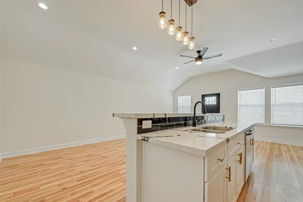 an empty room with a ceiling fan and window