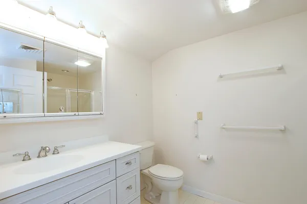 a bathroom with a sink a toilet and a mirror