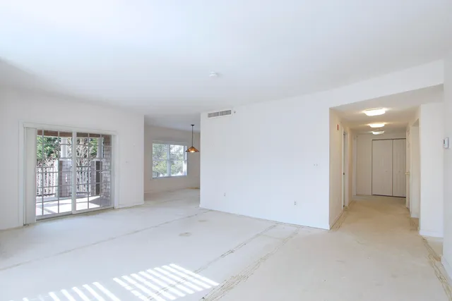 an empty room with windows and closet