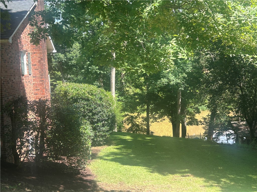 418 Saluda Road Williamston, SC 29697 - Photo 5 of 40 Lush landscaping and mature trees frame this delightful waterfront property.