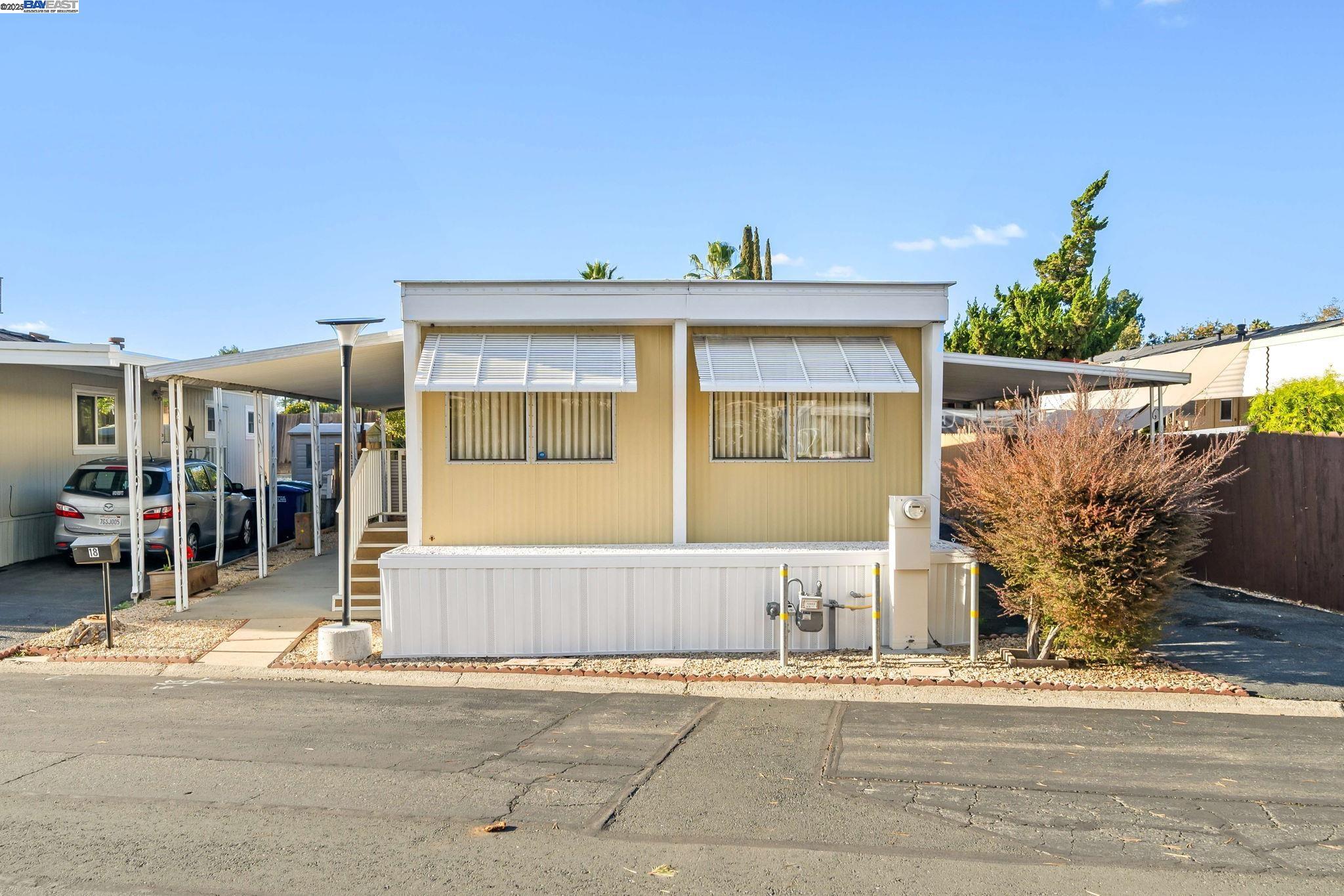 a view of a house with a yard and potted plants