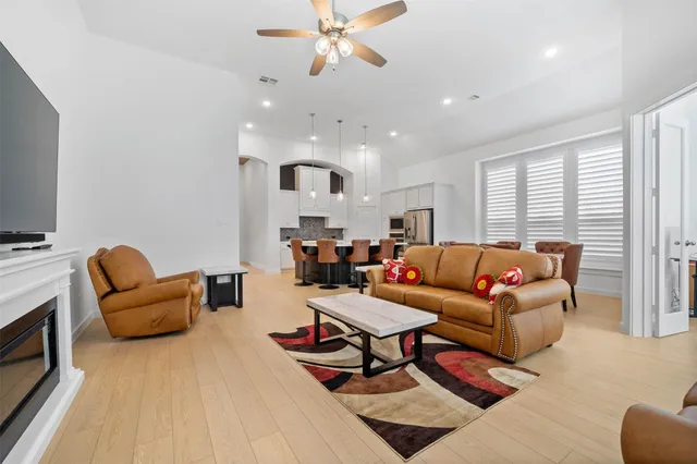 a living room with furniture a flat screen tv and a window
